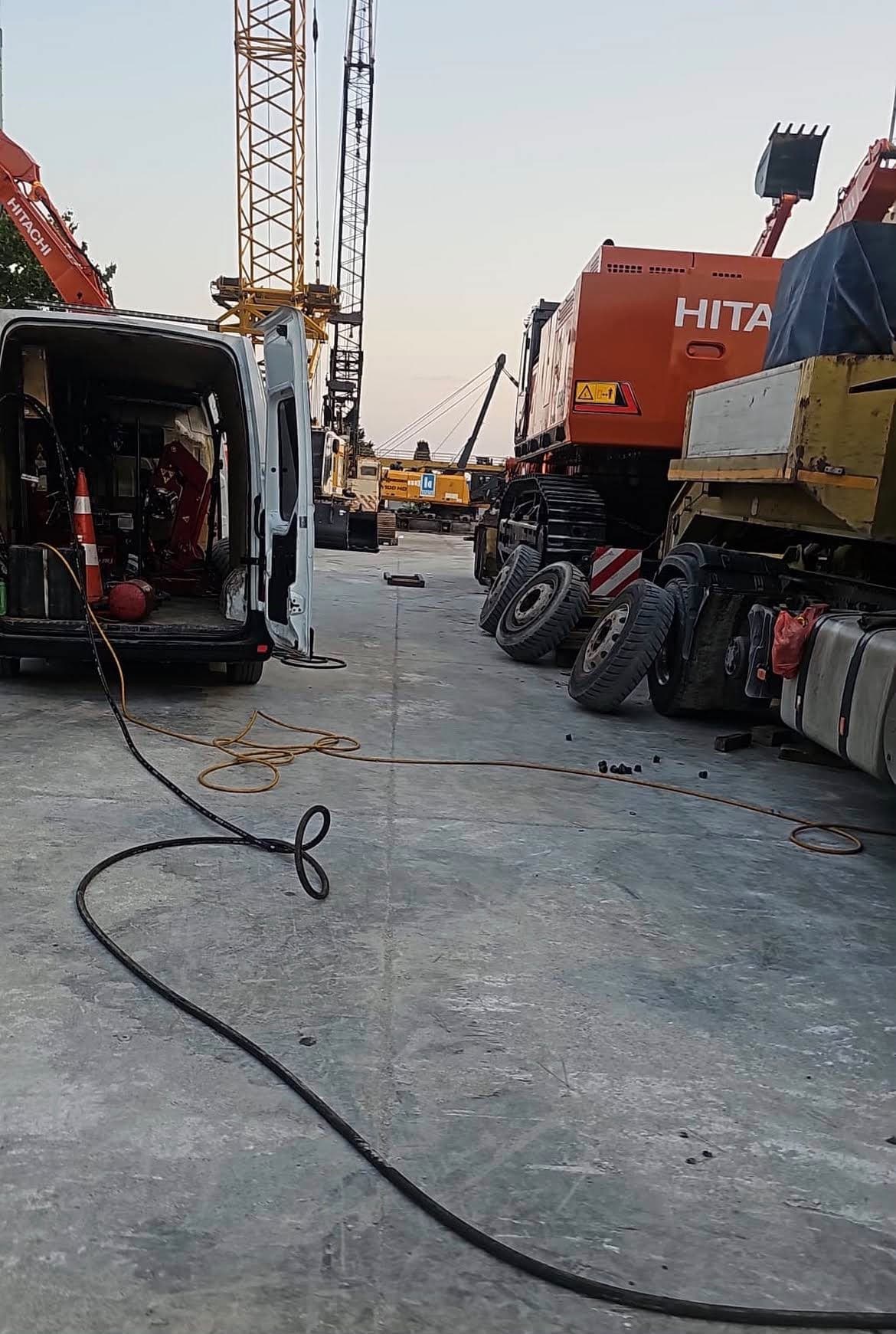 Şantiyede lastik servisi için bekleyen iş makinesi ve mobil servis aracı